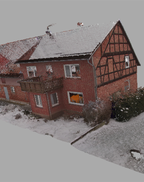 3D-Laserscan eines verschneiten Fachwerkhauses mit roter Klinkerfassade und Fachwerkgiebel.