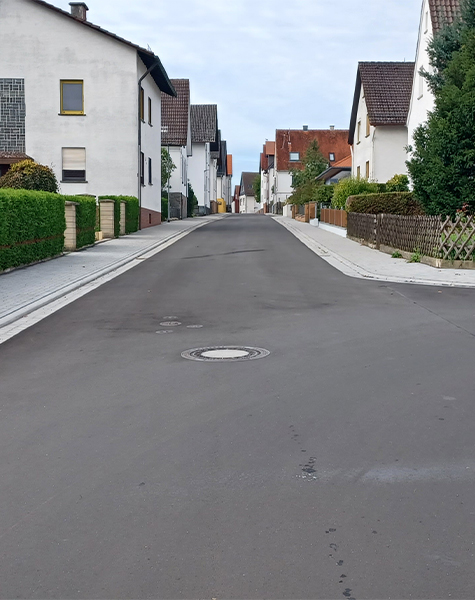 Neu asphaltierte Straße mit Gehwegen und angrenzender Wohnbebauung in Climbach.